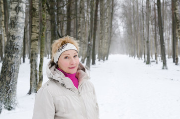 Fototapeta premium Portrait of a middle-aged woman on the background of a winter al