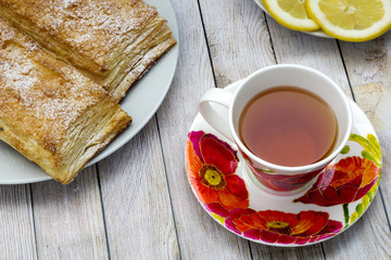 cup of tea with red poppies and flaky pies