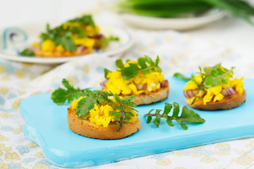 Bruschetta with scrambled eggs and arugula