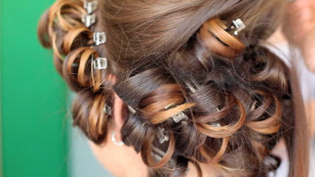 Hair stylist curling hair of future married woman