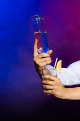 Young man bartender pouring a drink