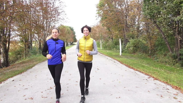 two woman talking and jogging