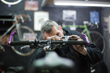 man repairing a bike - obrazy, fototapety, plakaty