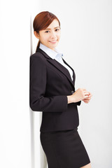 Obraz premium young businesswoman leaning against white wall in office