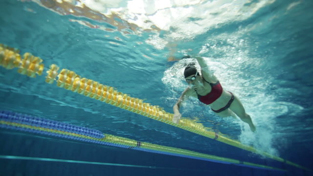 underwater view woman swimming crawl in pool with lanes
