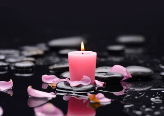 Beautiful red petals with candle and therapy stones