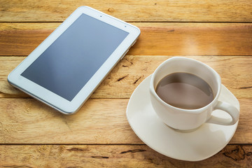 Fototapeta na wymiar Hot coffee and tablet on wood table