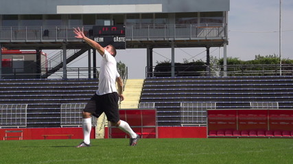 soccer player in slow motion during overhead kick on playing field
