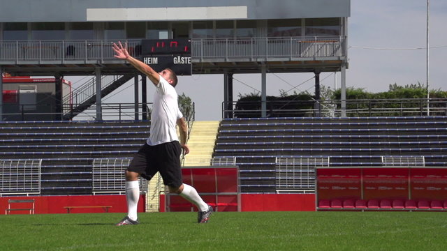soccer player in slow motion during overhead kick on playing field
