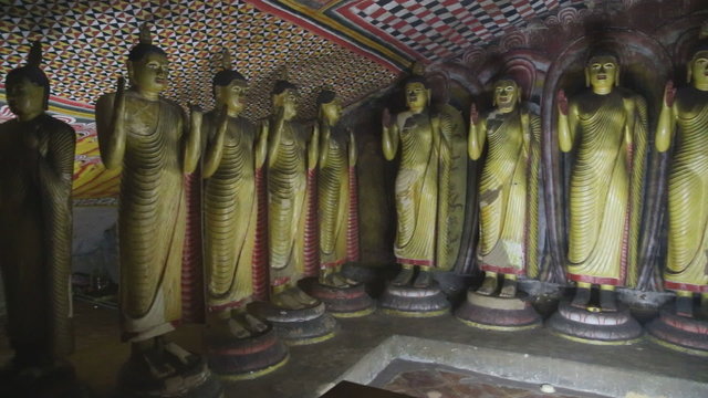 DAMBULLA, SRI LANKA - FEBRUARY 2014: The view of standing Buddhas at the Golden Temple of Dambulla. The Golden Temple of Dambulla is a World Heritage Site in Sri Lanka.