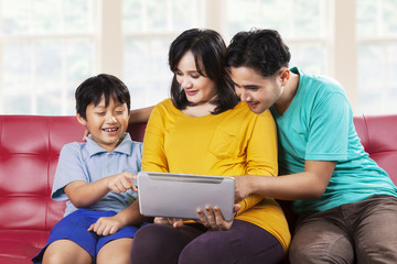 Fototapeta premium Two parents and their son using tablet