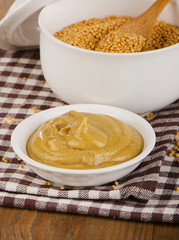 Mustard seeds and sauce on  wooden table