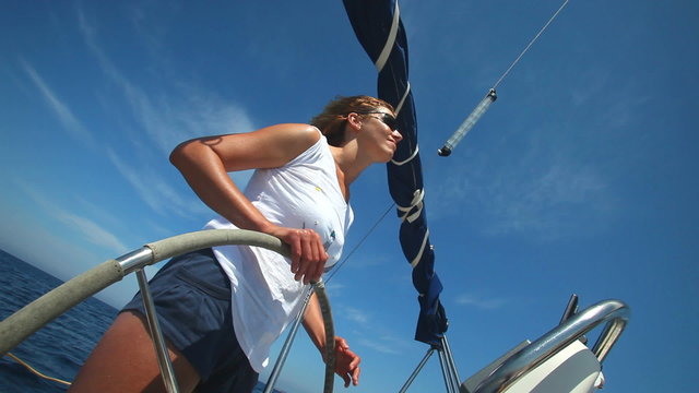 Woman at wheel steering sailboat on Adriatic sea in Croatia