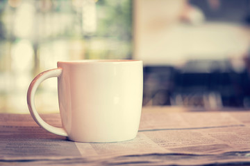 Coffee cup on newspaper in coffee shop