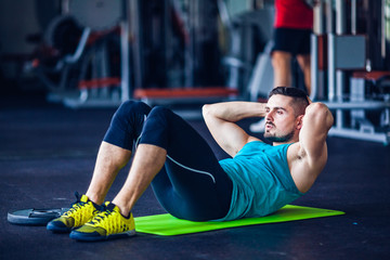 Fototapeta premium Crossfit instructor at the gym doing abs exercises
