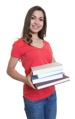 Lachende Studentin mit langen dunklen Haaren und Büchern