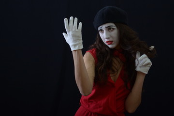 the girl is MIME wears white gloves .on a dark background