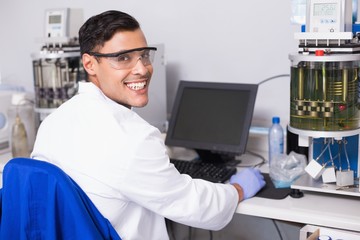 Smiling scientist working with computer