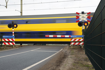 Naklejka premium double deck passenger train at railroad crossing