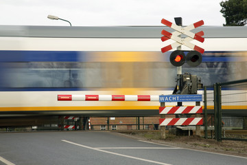 Fototapeta premium train speeding near railway crossing in holland