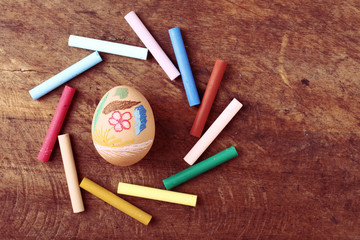 Easter egg with colorful crayon on wooden background
