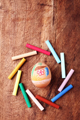 Easter egg with colorful crayon on wooden background