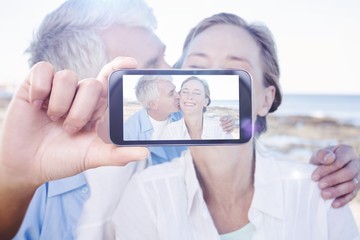 Composite image of hand holding smartphone showing