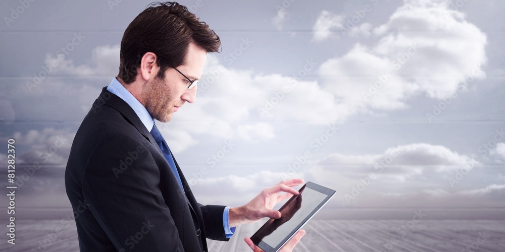 Poster Composite image of businessman standing while using a tablet pc