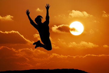 Happy girl woman jump against beautiful sunset. Freedom