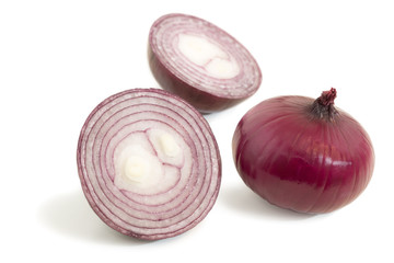 Closeup of a halved and a whole red onions isolated on white
