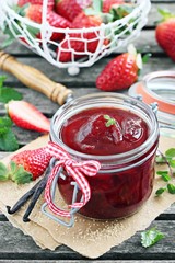 Homemade delicious strawberry jam on a rustic wooden table