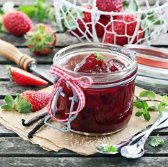 Homemade delicious strawberry jam on a rustic wooden table