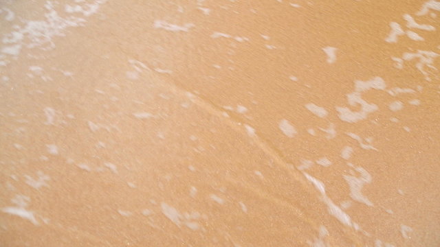 Waves washing over white sand in the tropics