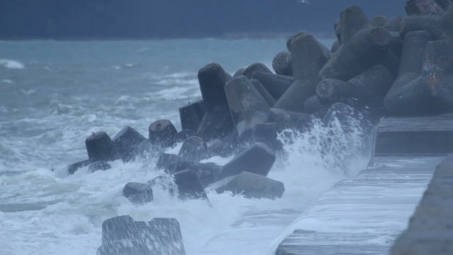 Waves splashing and gale force wind gusts harbor pier