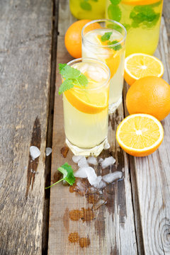 Cold orange soda in a glass on a wooden background