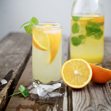 Cold orange soda in a glass on a wooden background