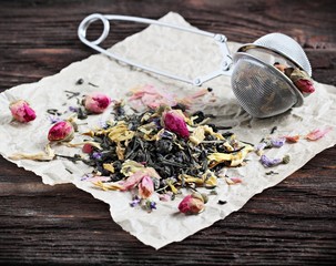 Green tea with dried flowers on a wooden table.
