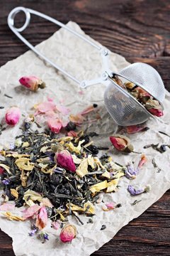 Green tea with dried flowers on a wooden table.