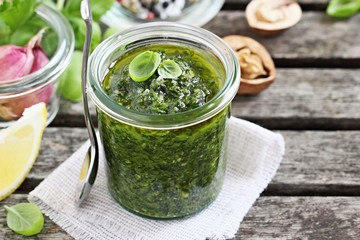 Basil pesto on a rustic wooden table.Selective focus.