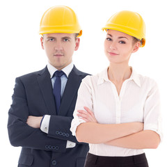 young man and woman in builder 's helmets isolated on white