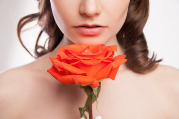 portrait of beautiful brunette woman with red rose