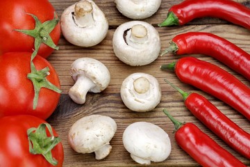 Chili Peppers, Fresh Tomatoes and  Mushrooms On Wooden Board