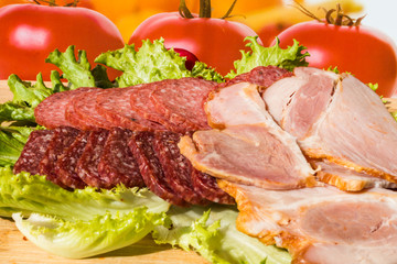 Cut pieces of smoked salam and ham with lettuce