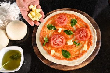 pizza and ingredients for pizza on wooden background