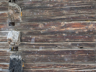 corner old cabin wall with falling snow background