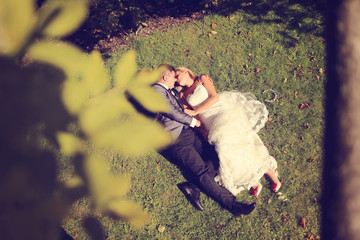 Bride and groom lying on grass
