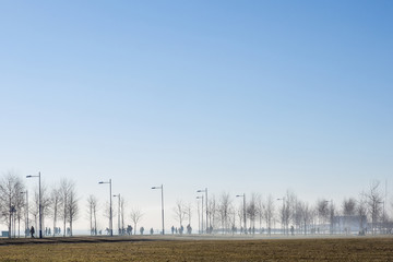 People walk in early spring park at seafront