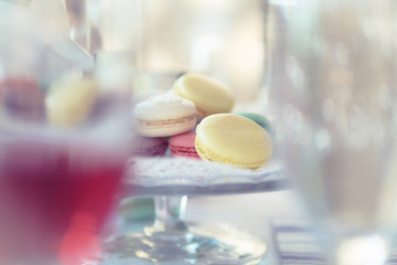 Pastel Macarons on Cake Stands between glasses