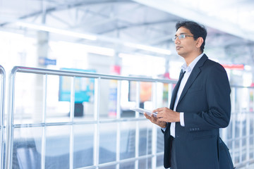 Man using tablet pc at train station