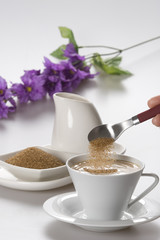Putting brown sugar in a cup of coffee
